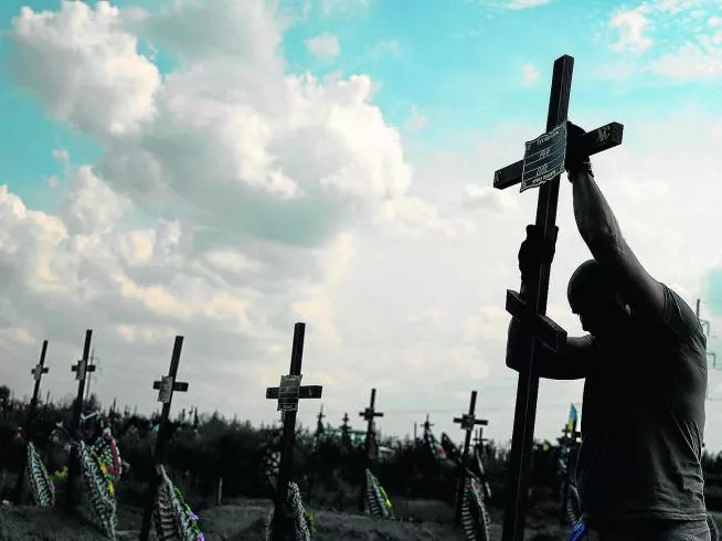 un-voluntario-coloca-el-pasado-agosto-un-cruz-con-un-numero-en-una-tumba-anonima-entre-enterramientos-de-asesinados-por-tropas-rusas-en-bucha