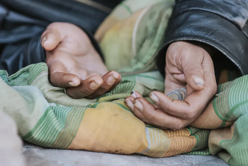 homeless-woman-holding-hands-out-for-help-scaled