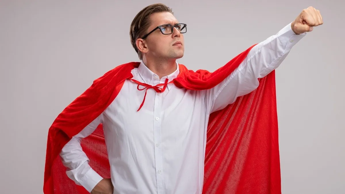 liderx_liderazgo_hombre-superheroe-_capa-roja-gafas-mirando-lado-cara-seria-haciendo-gesto-ganador-mano-lista-ayudar-pararse-sobre-pared-blanca_x1x.jpg_554688468