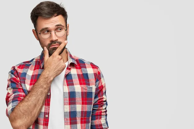 foto-hombre-barbudo-aspecto-agradable-sostiene-barbilla-mira-pensativamente-lado-sostiene-barbilla-enfoca-lado-contra-pared-blanca_273609-15069