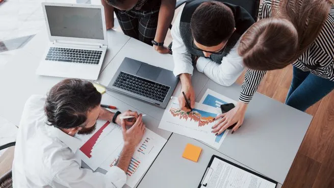 hermoso-elegante-personal-sentado-oficina-escritorio-usando-computadora-portatil-escuchando-colegajpg