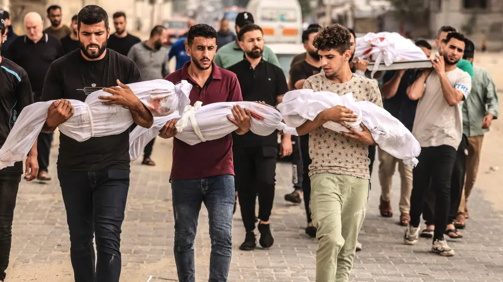 un-grupo-de-hombres-sostiene-los-cuerpos-sin-vida-de-tres-pequenos-en-gaza